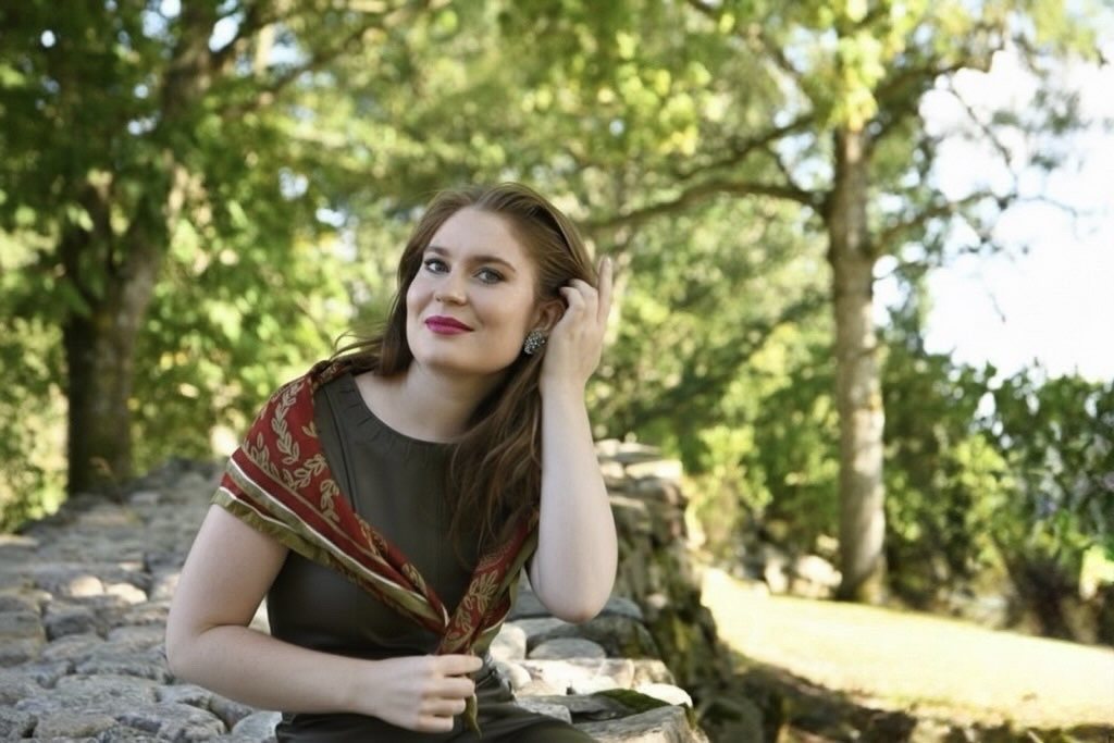 Karolina Bengtsson seated by a stone wall